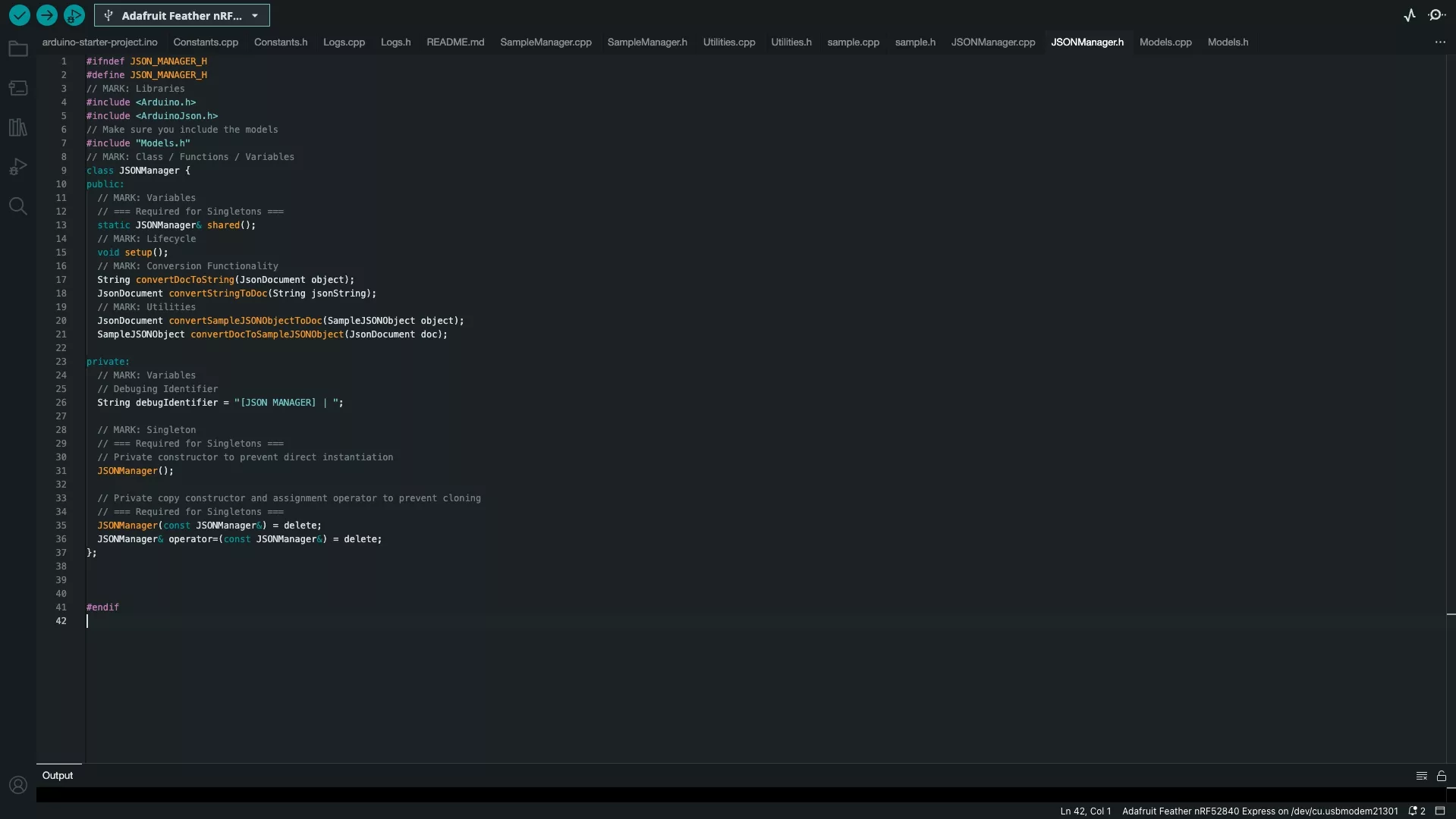 A screenshot of the Arduino IDE showing the header file for the JSON Manager Singleton Class.